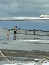 A family enjoys a fun day at the beach, exploring shallow waters during a sandbar stop — perfect for creating lasting memories on the water.