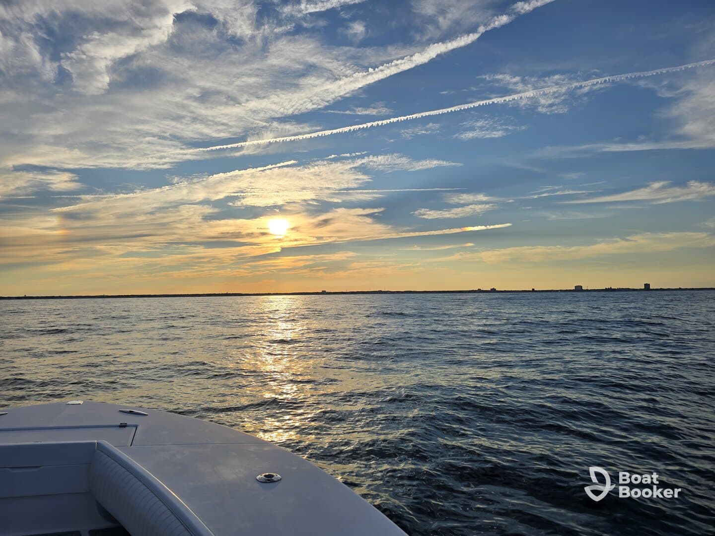 A serene sunset view from the deck of a boat, showcasing the tranquil waters and vibrant sky, perfect for evening cruises.