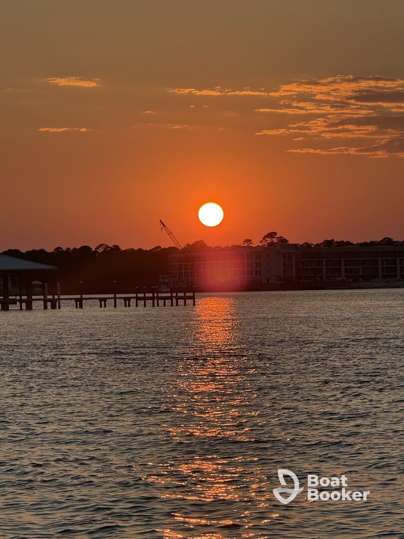 A stunning sunset casts a warm glow over the water, creating a picturesque reflection — perfect for capturing serene moments on the water.