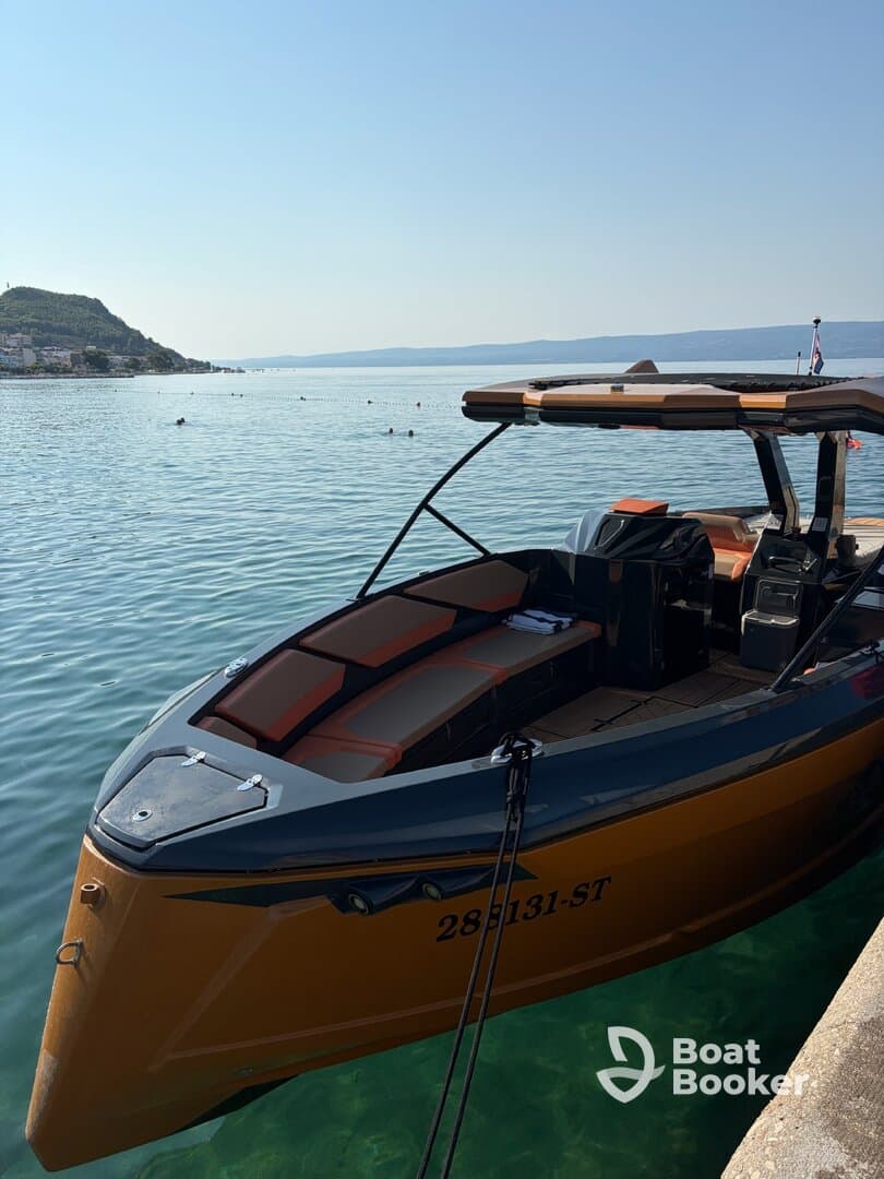 A sleek speedboat docked by the shore, showcasing its stylish design against a serene water backdrop — perfect for summer adventures.