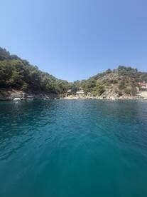 A serene view of a picturesque coastline with lush greenery and clear turquoise waters, perfect for exploring hidden harbors and enjoying nature's beauty.