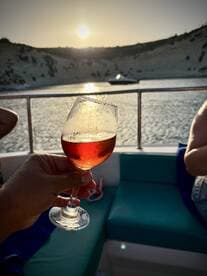A toast with cocktails at sunset aboard a boat, capturing the essence of relaxation and celebration on the water.
