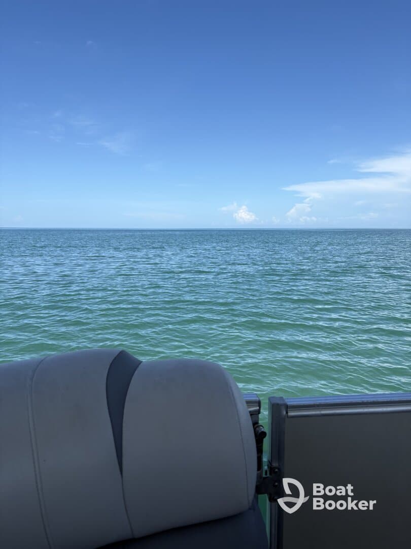 A close-up view of the seating area on a pontoon boat, showcasing the serene waters and clear blue sky — perfect for relaxing days on the water.