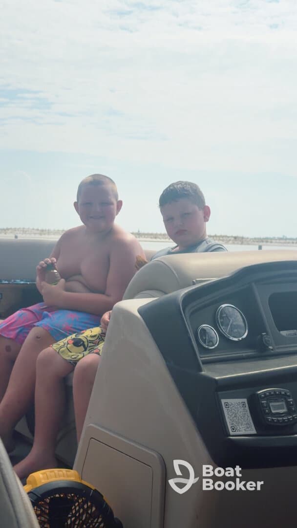 Two boys enjoy a sunny day on a boat, capturing the joy of childhood adventures on the water.