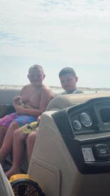 Two boys enjoy a sunny day on a boat, capturing the joy of childhood adventures on the water.