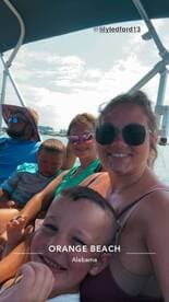 A joyful family enjoys a boat ride in Orange Beach, Alabama, capturing a fun moment together under the sun.