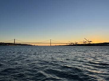 A stunning sunset view featuring a bridge silhouetted against the colorful sky, capturing the serene beauty of the waterfront.
