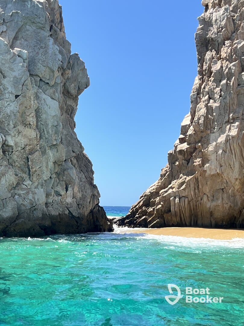 A stunning view of a rocky coastline with turquoise waters, showcasing the natural beauty of the beach — perfect for exploring hidden gems while boating.