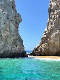A stunning view of a rocky coastline with turquoise waters, showcasing the natural beauty of the beach — perfect for exploring hidden gems while boating.