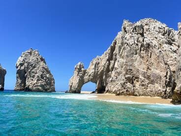 Breathtaking view of iconic rock formations at Cabo San Lucas, surrounded by crystal-clear waters — a must-see destination for boat tours and scenic cruises.