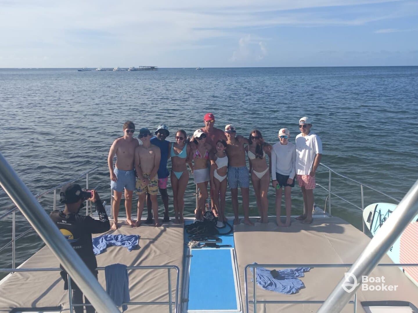 A lively group poses for a photo on the deck of a boat, capturing a memorable moment during their fun-filled day on the water.