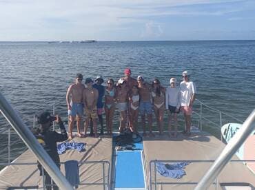 A lively group poses for a photo on the deck of a boat, capturing a memorable moment during their fun-filled day on the water.