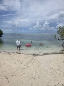 A group enjoys a relaxing day at the beach, swimming and floating in the clear waters — perfect for family outings or friends' get-togethers.