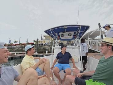 A group of friends enjoys a lighthearted moment aboard a boat, showcasing camaraderie and fun in a vibrant setting.