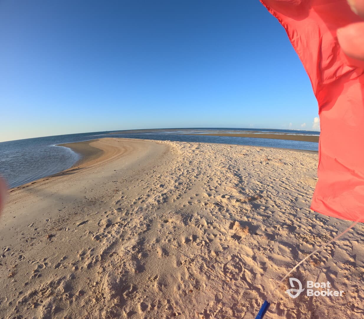 A serene view of a sandy sandbar extending into the turquoise waters, perfect for beach outings and relaxation in nature.