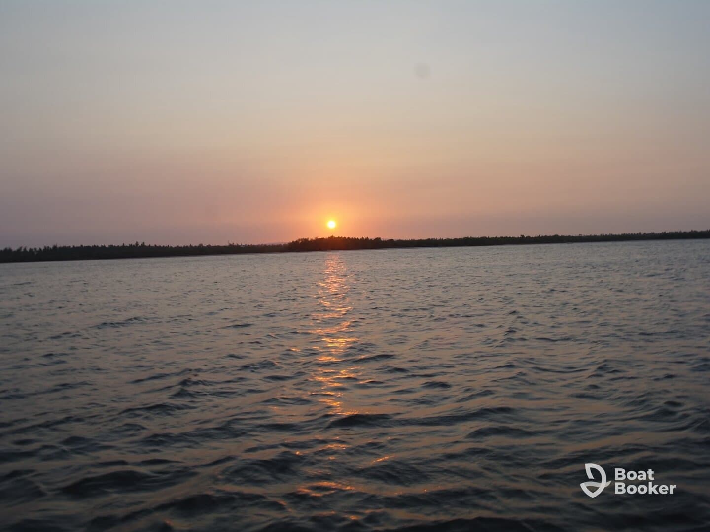 A serene sunset over calm waters, showcasing the beauty of nature — perfect for peaceful evening boat rides.