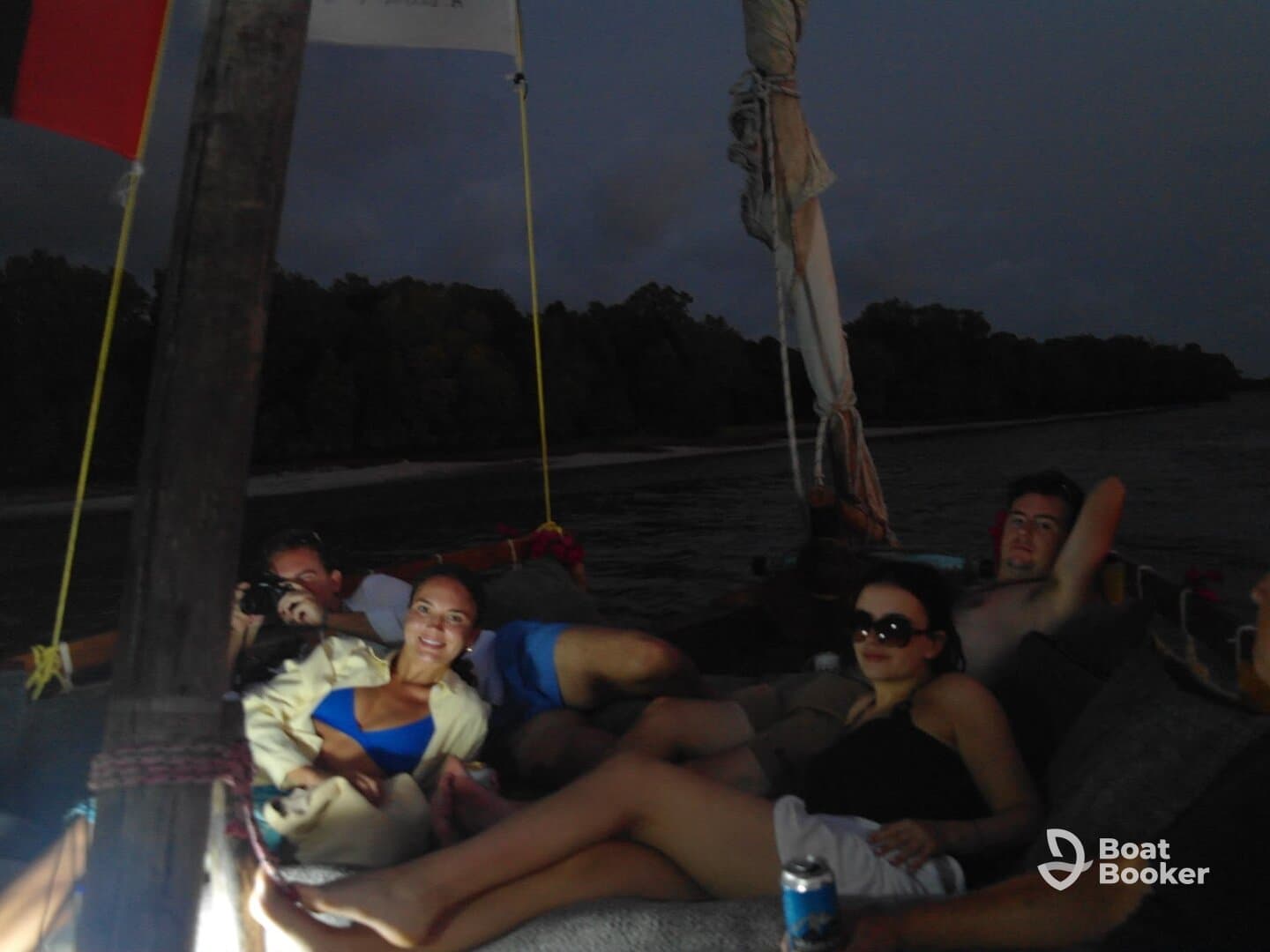A group of friends relaxes on a boat during the evening, enjoying each other's company and the tranquil waters — perfect for a memorable night out on the water.