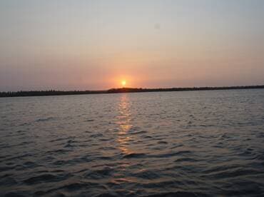 A serene sunset over calm waters, showcasing the beauty of nature — perfect for peaceful evening boat rides.