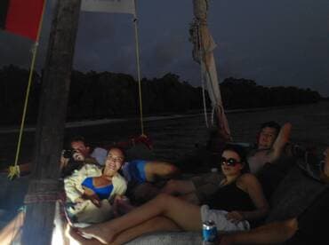 A group of friends relaxes on a boat during the evening, enjoying each other's company and the tranquil waters — perfect for a memorable night out on the water.