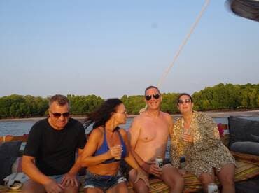 A lively group enjoys drinks and laughter aboard a boat, capturing the essence of a fun-filled day on the water.