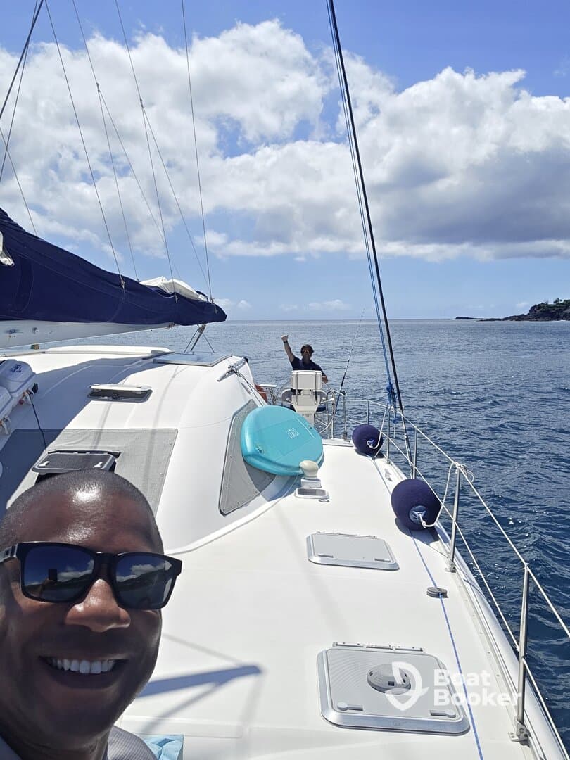 A joyful moment aboard a catamaran, with two people enjoying the ocean breeze while sailing — perfect for adventure seekers and sailing enthusiasts.