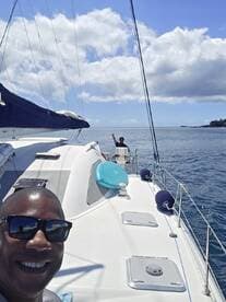A joyful moment aboard a catamaran, with two people enjoying the ocean breeze while sailing — perfect for adventure seekers and sailing enthusiasts.