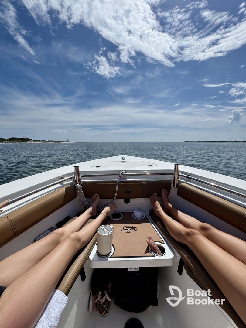 Two friends relax on the deck of a boat under the bright sun, enjoying a serene day on the water — perfect for unwinding and soaking up the sun.