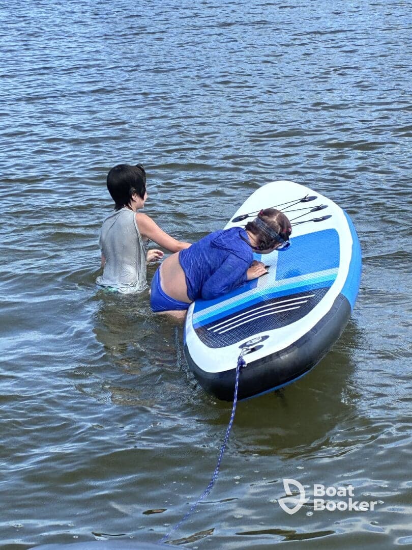 Two children enjoy paddleboarding in the water, showcasing a fun and active day on the water.