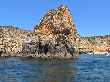 A stunning view of rugged cliffs along the coastline, showcasing the natural beauty of the area — perfect for scenic boat tours and exploration.