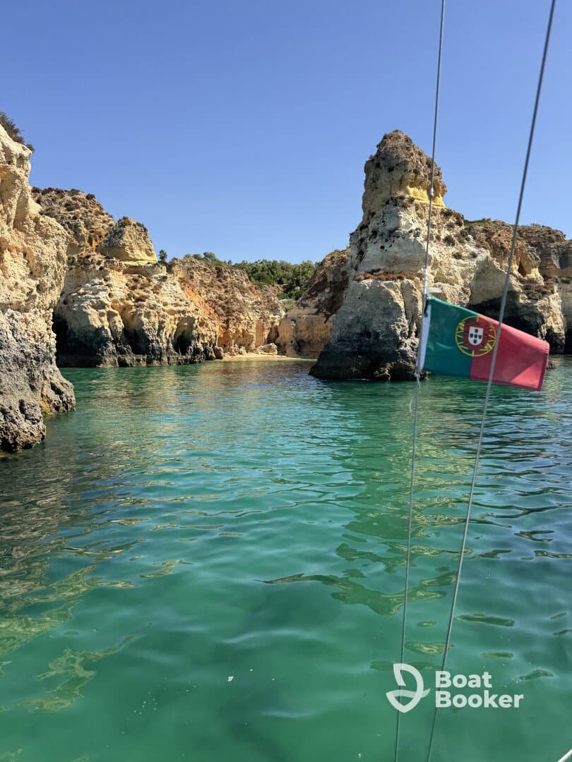 A stunning view of the rugged coastline in Portugal, showcasing vibrant turquoise waters and unique rock formations — perfect for exploring by boat.