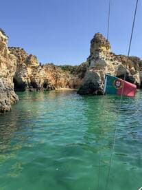 A stunning view of the rugged coastline in Portugal, showcasing vibrant turquoise waters and unique rock formations — perfect for exploring by boat.