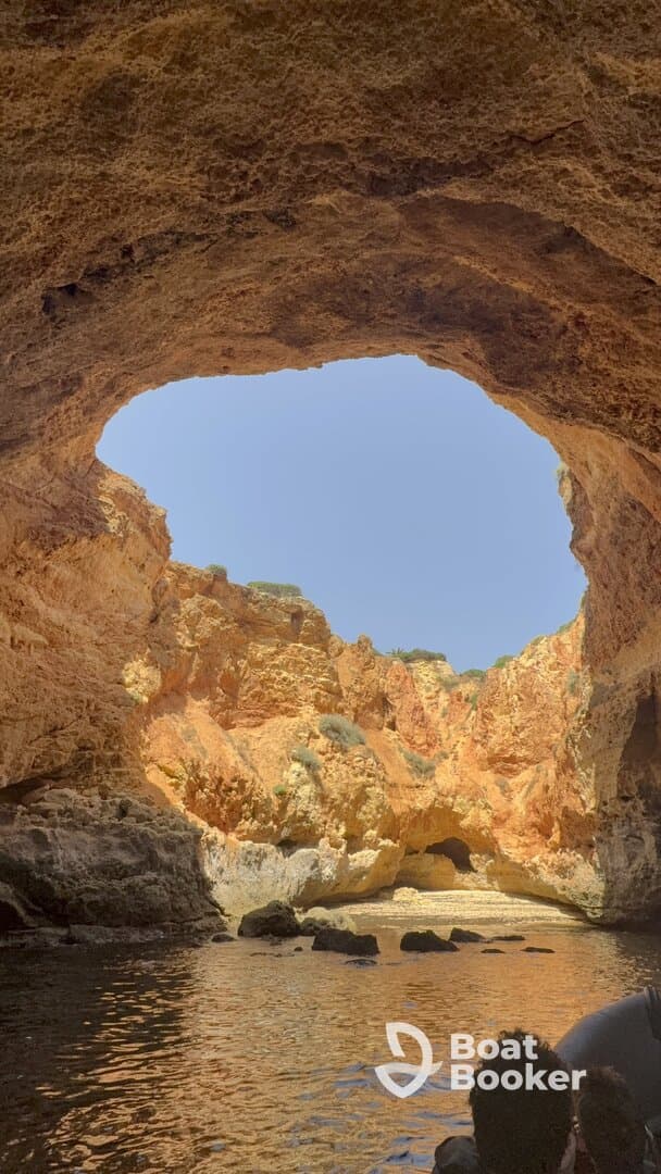 A stunning view from inside a cave, showcasing the vibrant rock formations and tranquil waters — a perfect spot for exploration and adventure on the coast.