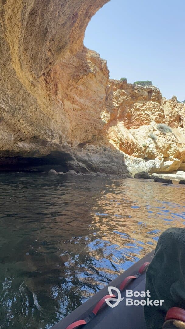 A scenic view of a cave entrance while kayaking, showcasing the stunning rock formations and tranquil waters — perfect for adventure seekers exploring coastal landscapes.