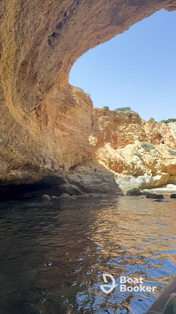 A stunning view of a coastal cave reflecting the vibrant colors of the rock formations, perfect for exploring scenic destinations by boat.