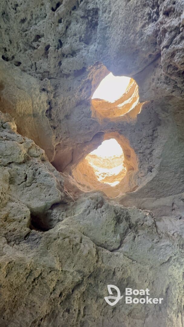An abstract view of rock formations with light filtering through openings, creating an intriguing natural pattern.