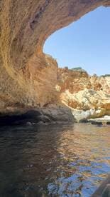 A stunning view of a coastal cave reflecting the vibrant colors of the rock formations, perfect for exploring scenic destinations by boat.
