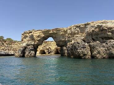 A stunning view of a natural rock arch along the coastline, showcasing the beauty of the landscape — perfect for sightseeing and exploring unique geological formations.