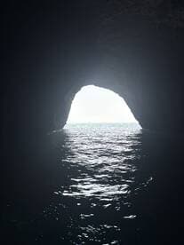 A stunning view of a cave opening leading to shimmering waters, showcasing a beautiful natural landmark perfect for exploration and adventure.