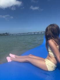 A child enjoys a sunny day on a floating mat in the water, capturing the essence of summer fun and relaxation.