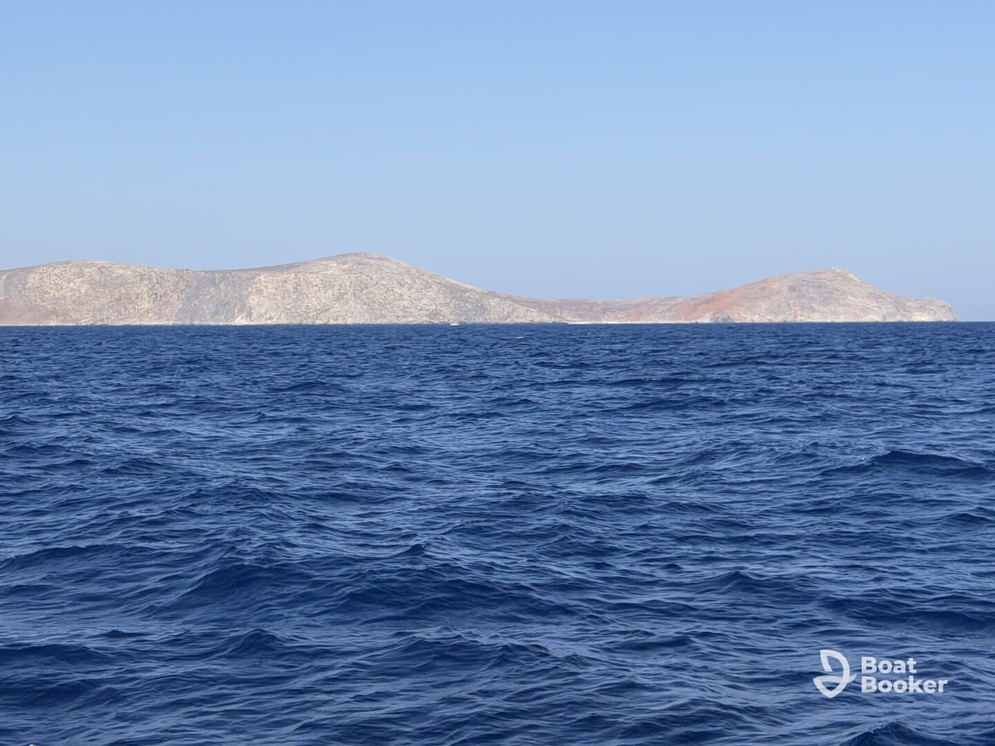 A stunning view of distant islands against a clear blue sky, showcasing the beauty of the coastline — perfect for island-hopping adventures.