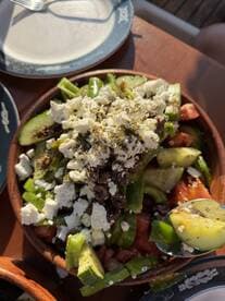 A vibrant salad featuring fresh vegetables and feta cheese, perfect for enjoying onboard during a relaxing day at sea.