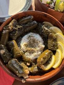 A delicious serving of stuffed grape leaves with yogurt and lemon, perfect for onboard catering during a boat trip.