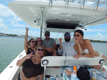A lively group of friends enjoys their time aboard a boat, celebrating and having fun on the water. Perfect for capturing memorable moments during a day out at sea.