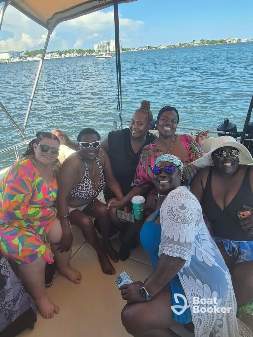 A joyful group of friends enjoys a fun day on the boat, capturing memories and celebrating together on the water.