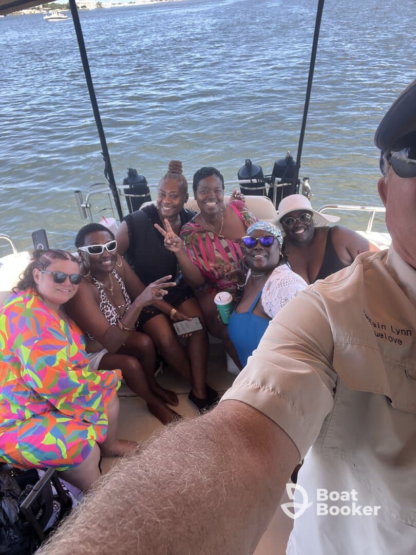 A joyful group of friends poses for a selfie aboard a boat, capturing the fun and camaraderie of their day on the water.