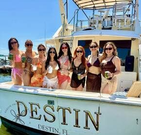 A lively group of friends celebrates on a private boat in Destin, FL, enjoying drinks and sunshine — perfect for a fun day on the water.