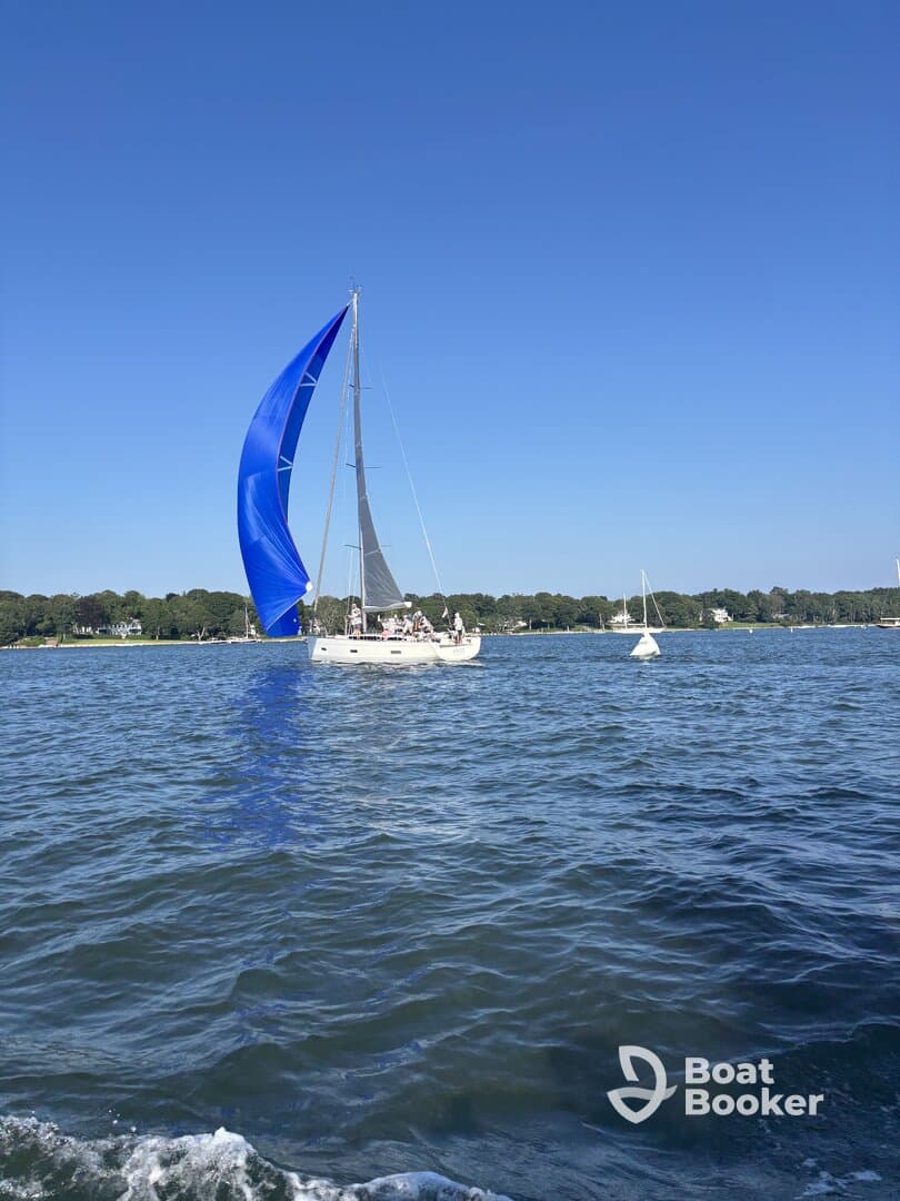A vibrant sailboat with a striking blue sail glides through the water, showcasing the beauty of sailing on a clear day. Perfect for adventure seekers and sailing enthusiasts.
