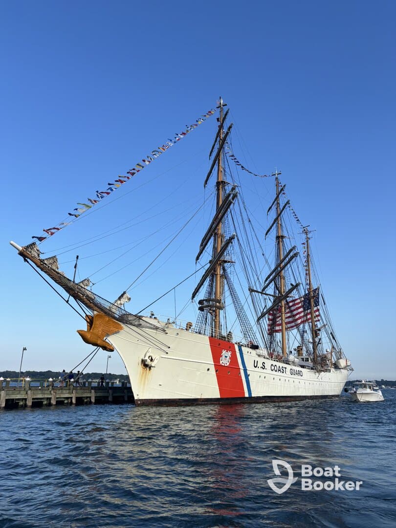 A majestic view of the U.S. Coast Guard tall ship, adorned with colorful flags, docked and ready for visitors — a perfect representation of maritime heritage.