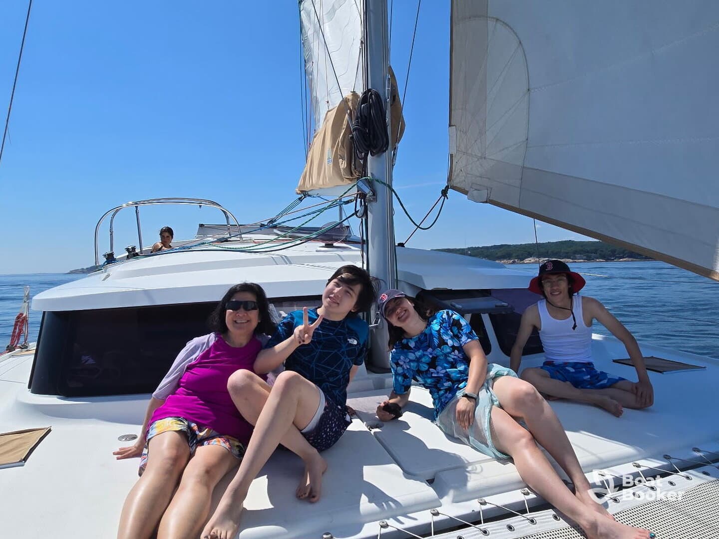 A cheerful group enjoys a sunny day sailing on a yacht, capturing moments of relaxation and fun on the water.