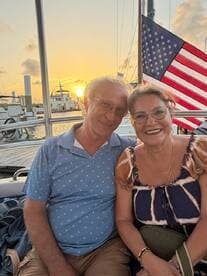 A couple enjoys a romantic moment together at sunset on a boat, capturing the essence of love and celebration on the water.